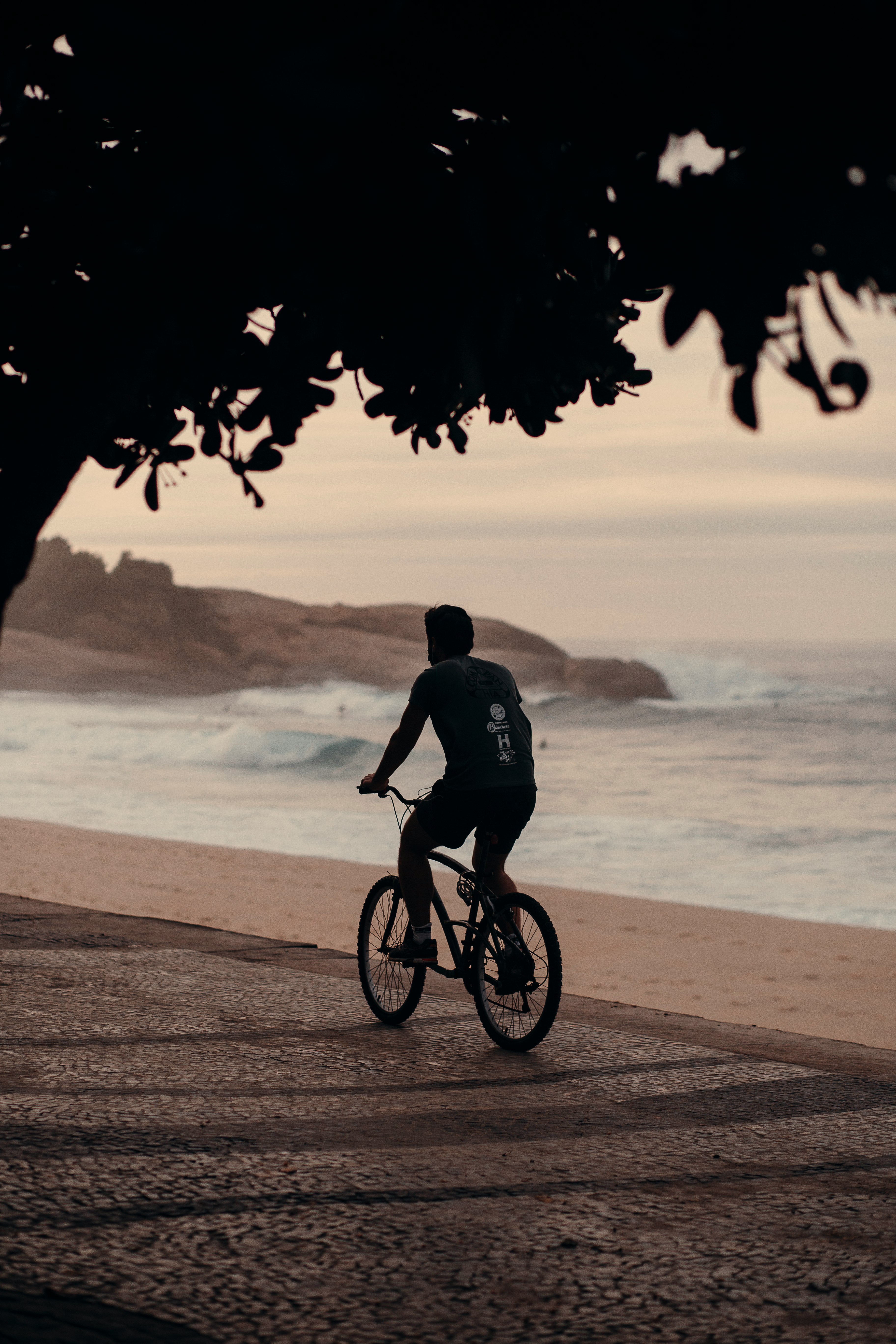 man in black shirt riding bicycle on beach during daytime